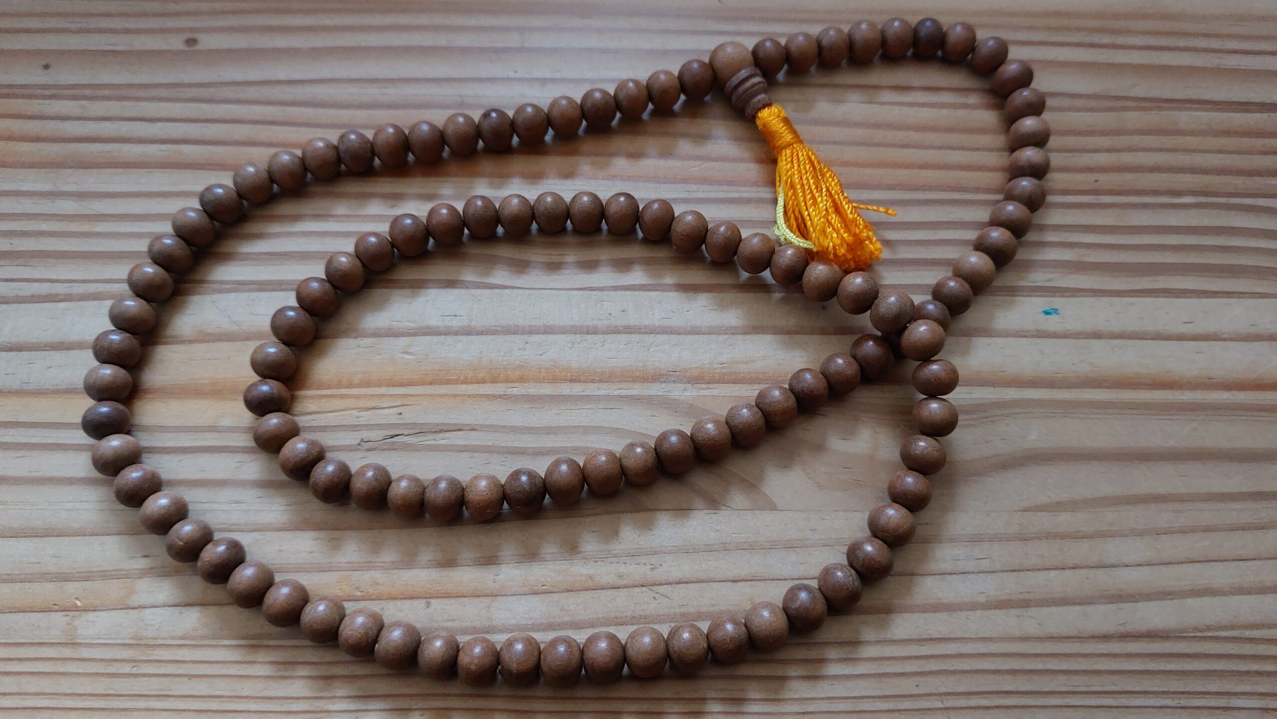 Bild einer Mala, einer Perlenkette mit 108 Holzperlen, wie sie bei der Meditation verwendet wird